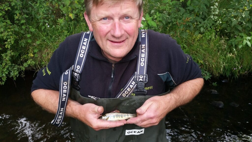Andy Croft (survey and monitoring) holding the salmon parr that was captured on the River Loud