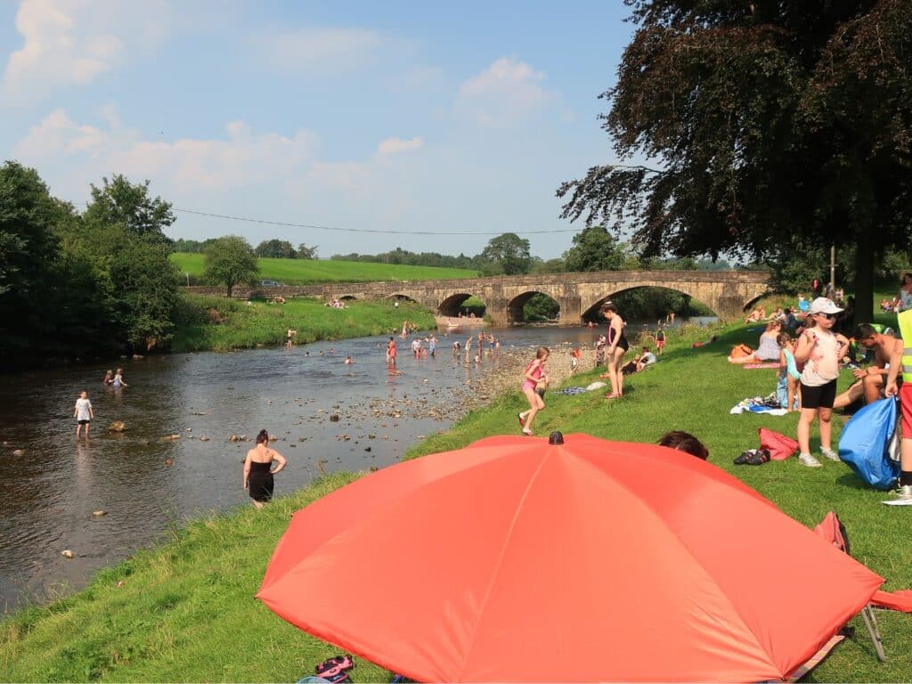 A photo of bathers and picnickers at Edisford Bridge, Clitheroe all geared up for water safety